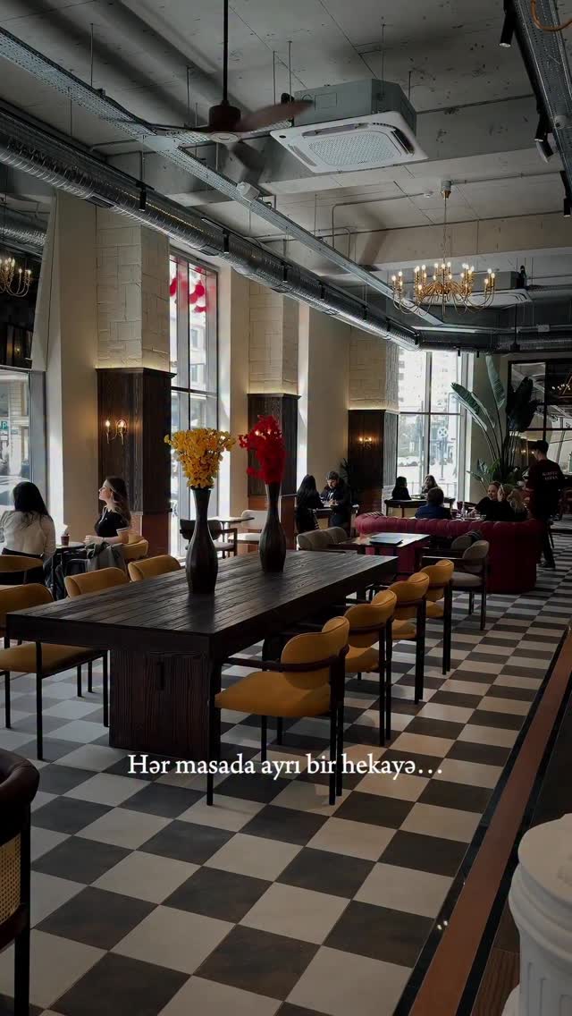 Xəzər Residence dining room — chandeliers, checkered floor, long communal table